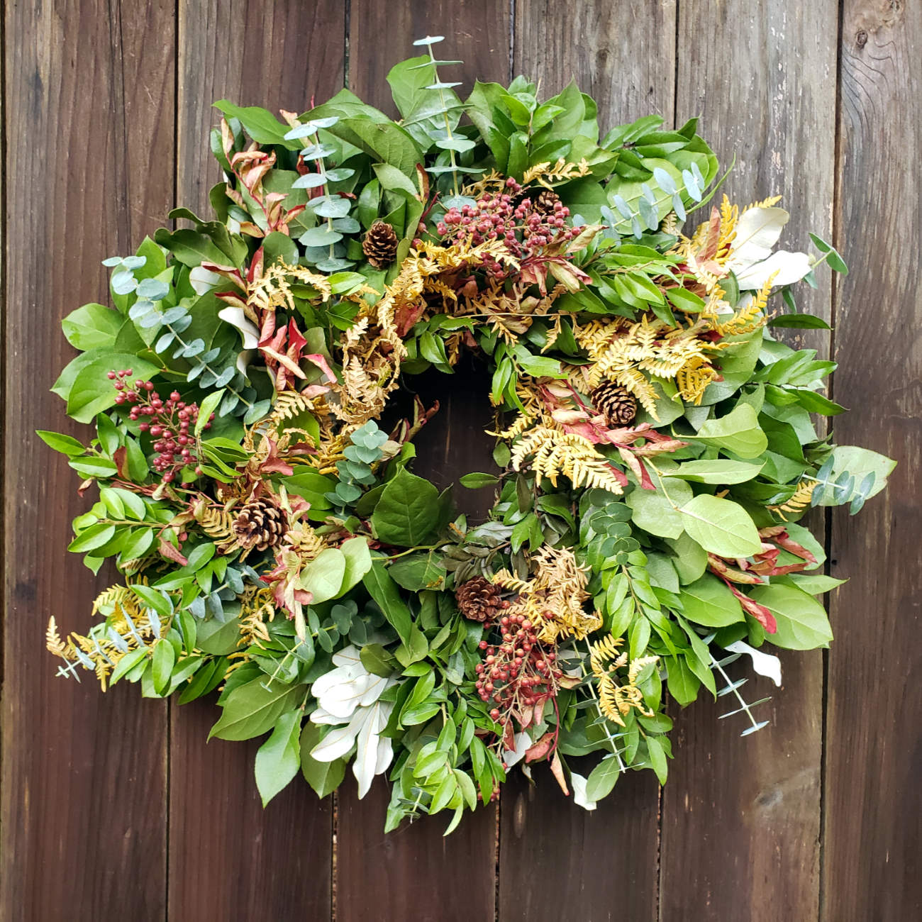 beautiful everlasting wreath with pepperberry on fence
